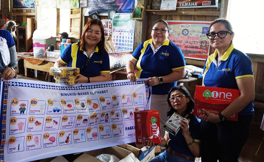 Project Chair Joy, President Stephanie and Service Director PP Bing showing the binukid based alphabet to teach teh talaanding tribe the alphabet with words using their own language for easier understanding and rentention. 